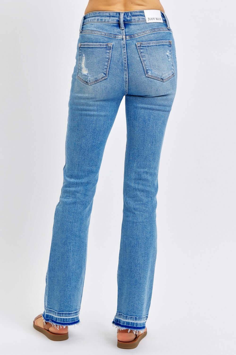 a woman in blue jeans with her back to the camera