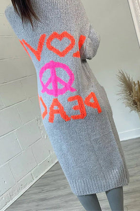 a woman is wearing a peace sign sweater