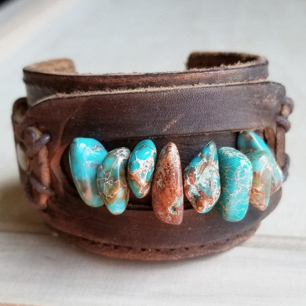 a leather bracelet with turquoise and brown beads