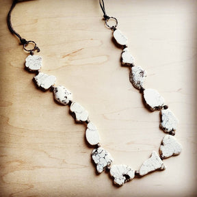 a necklace made of white rocks on a wooden surface