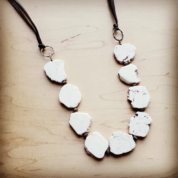 a necklace made of white rocks on a wooden surface