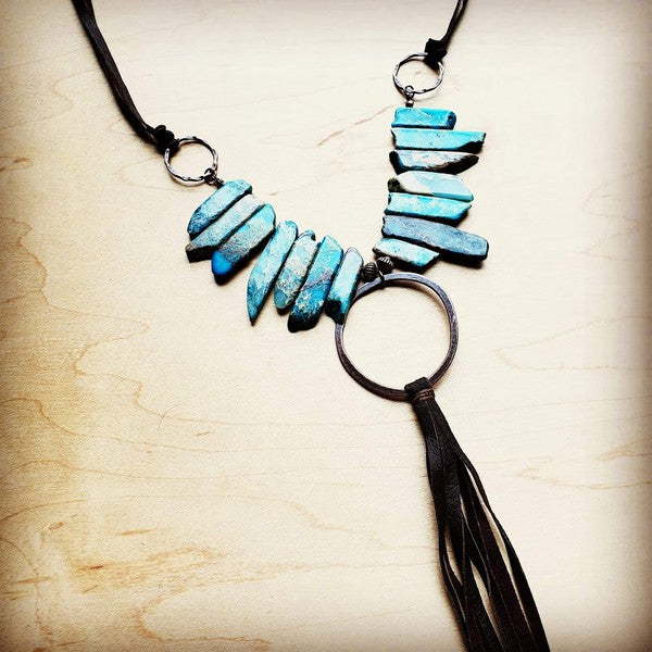 a necklace with a leather tassel and turquoise beads