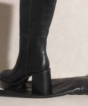 Close-up of black platform knee-high boots heel