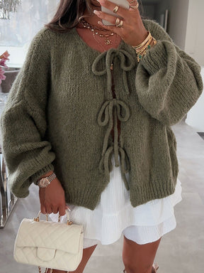 Army green tied cardigan styled with white dress