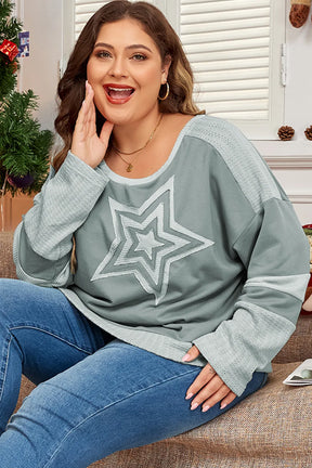 Model wearing plus size sage top with star design