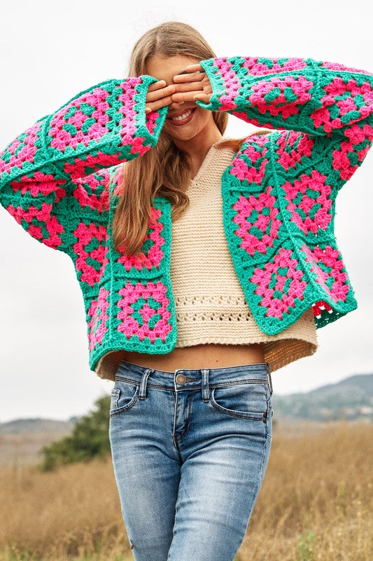 Two-tone floral crochet cardigan in pink and green.