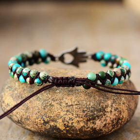 Close-up of turquoise beaded bracelet with hand charm