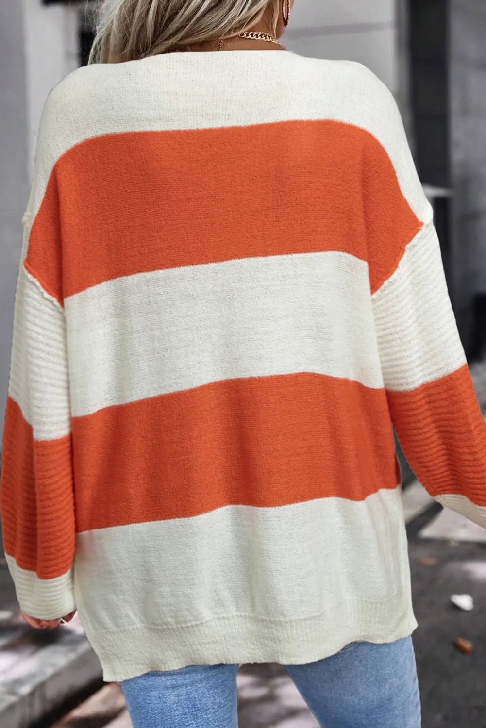 Orange and white color block V-neck sweater, back view