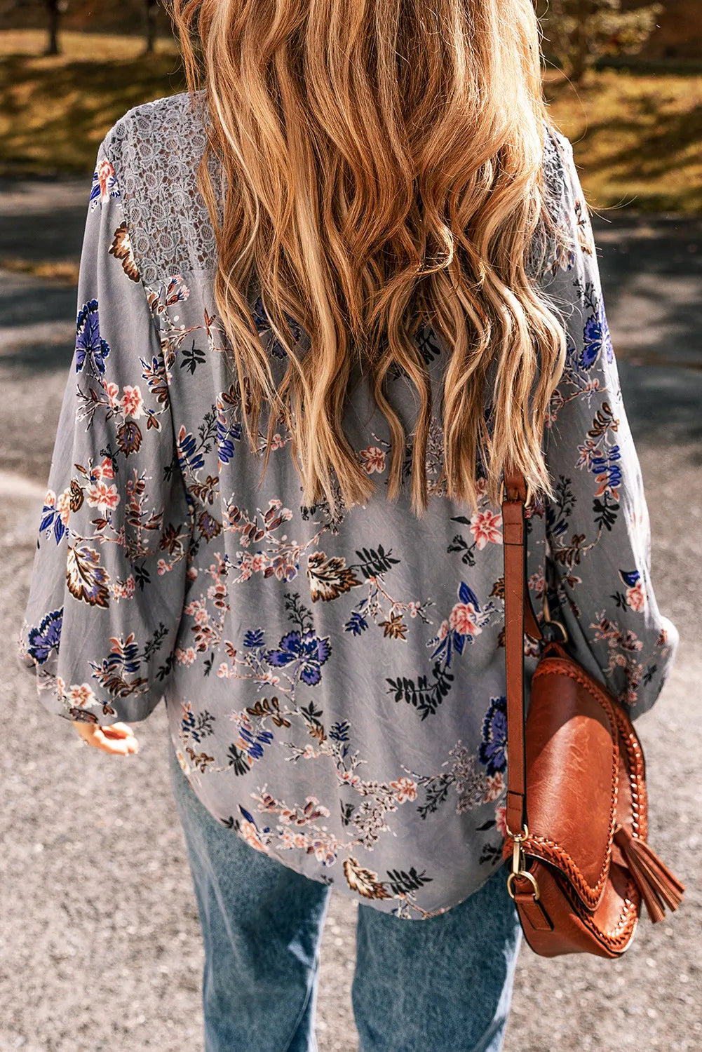 a woman with long hair walking down a street