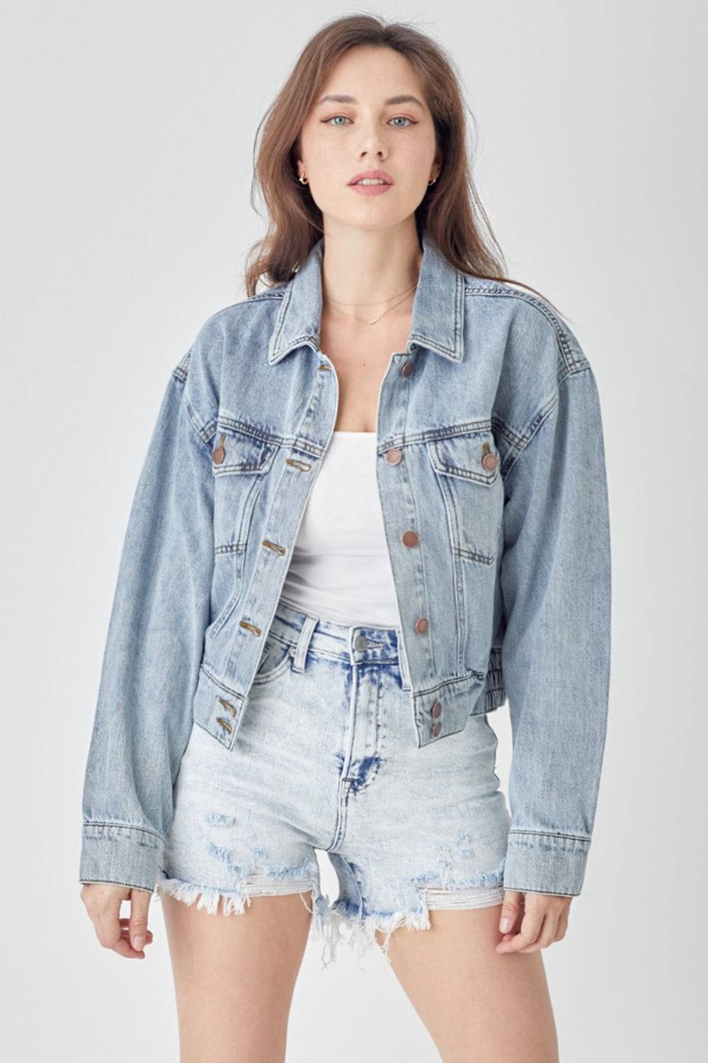 a woman wearing a denim jacket and shorts