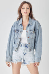 a woman wearing a denim jacket and shorts