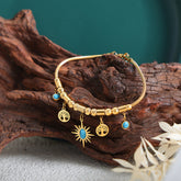 Gold bracelet with turquoise charms on wood