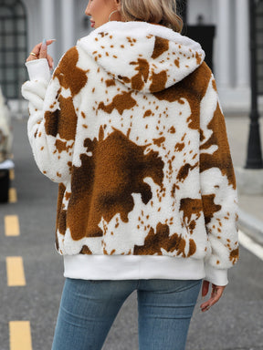 a woman wearing a brown and white cow print hoodie