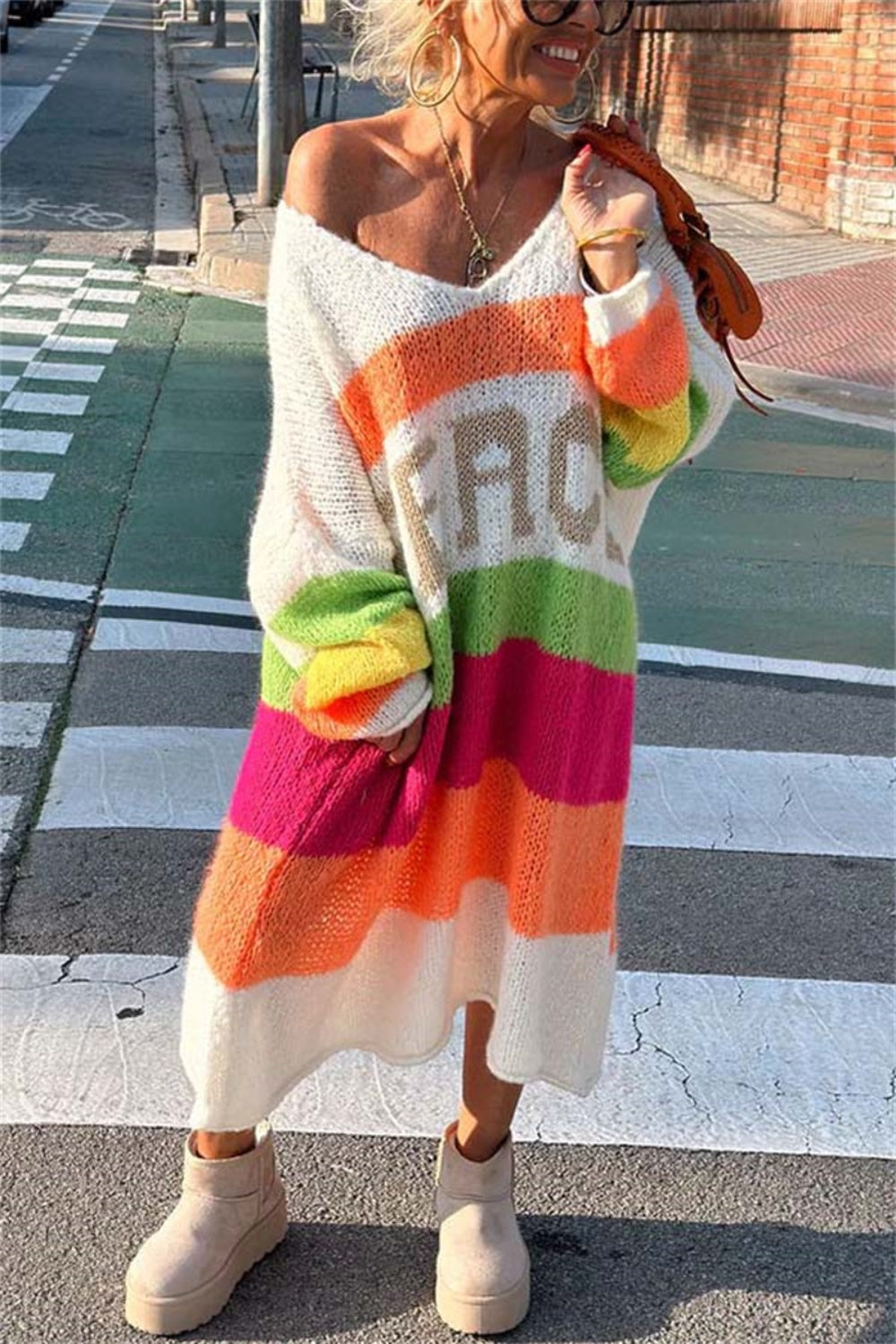 Colorful striped sweater dress with 'PEACE' text, street style.