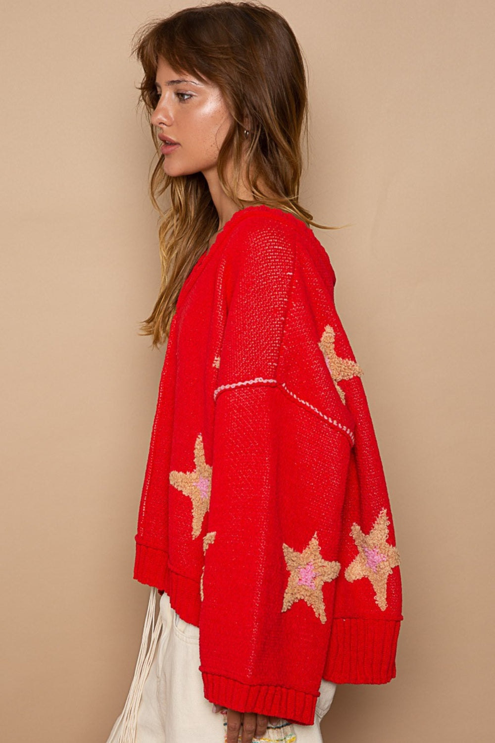 Red sweater with star patches, side profile.