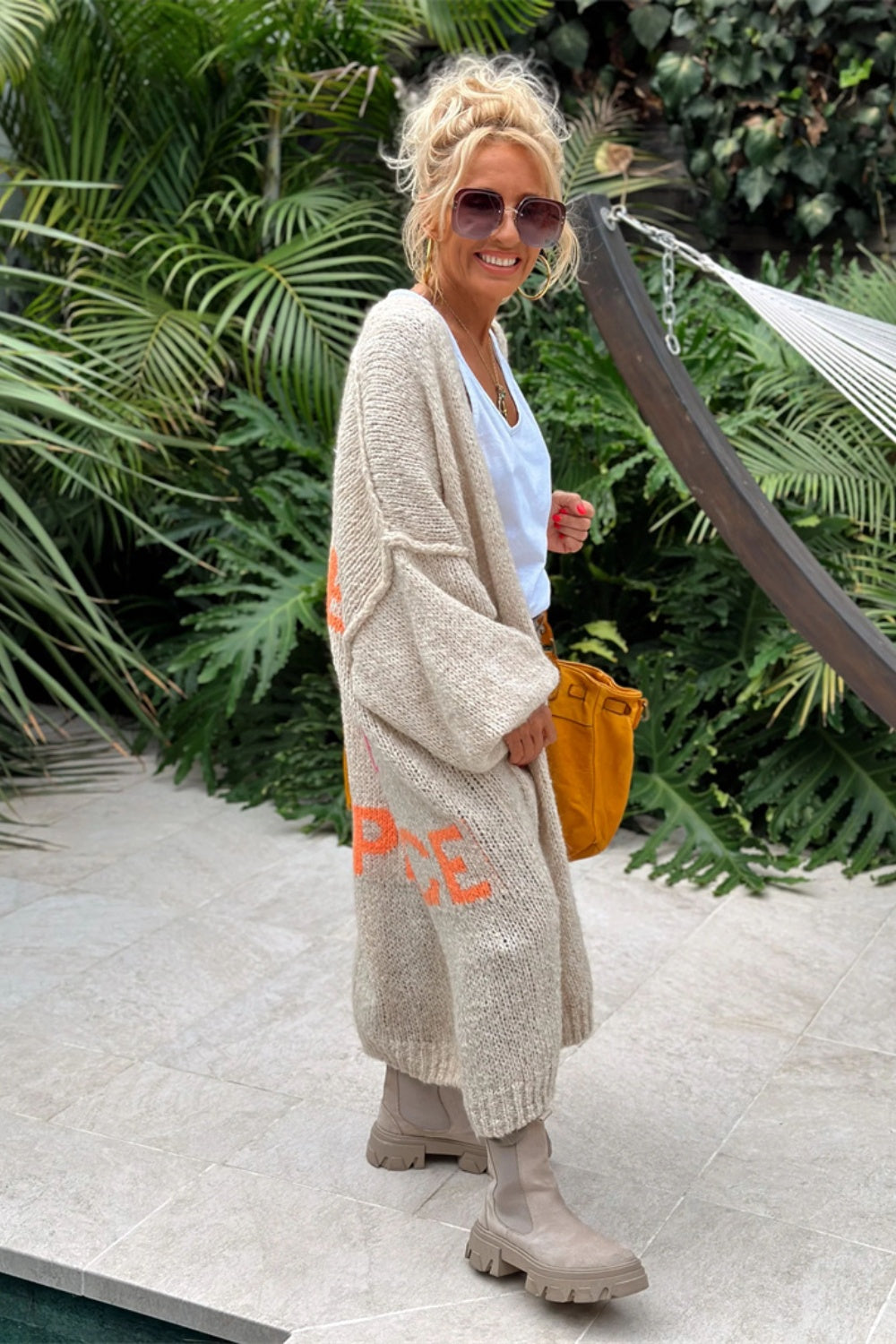 Woman in beige cardigan with white shirt and jeans