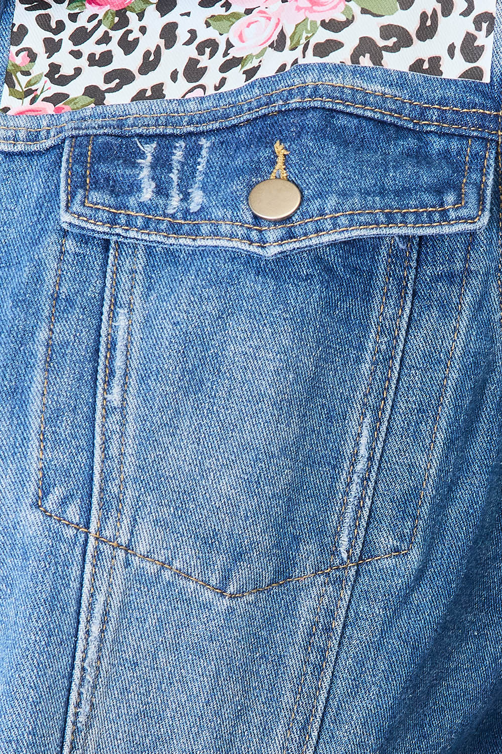 Close-up of leopard floral pattern on denim jacket.