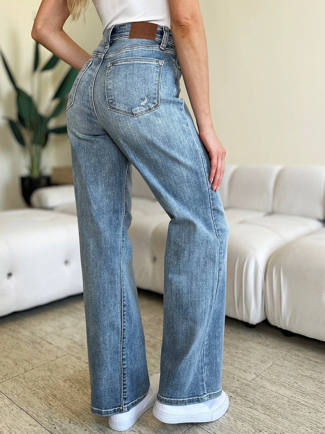 a woman standing in a living room with her hands on her hips