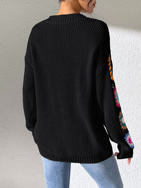 Back view of black V-neck sweater with crochet flower sleeves.