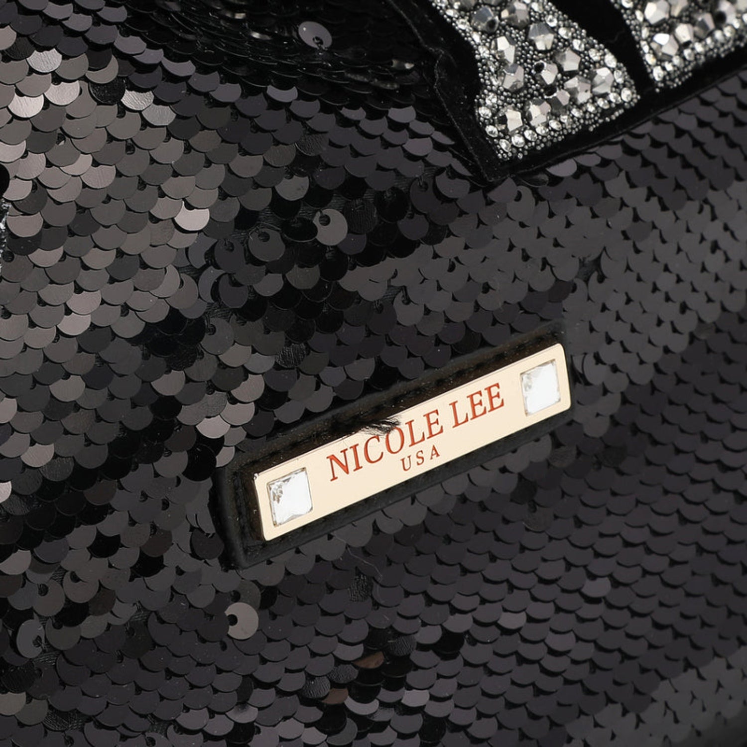 Close-up of Nicole Lee USA logo on sequin patch bag