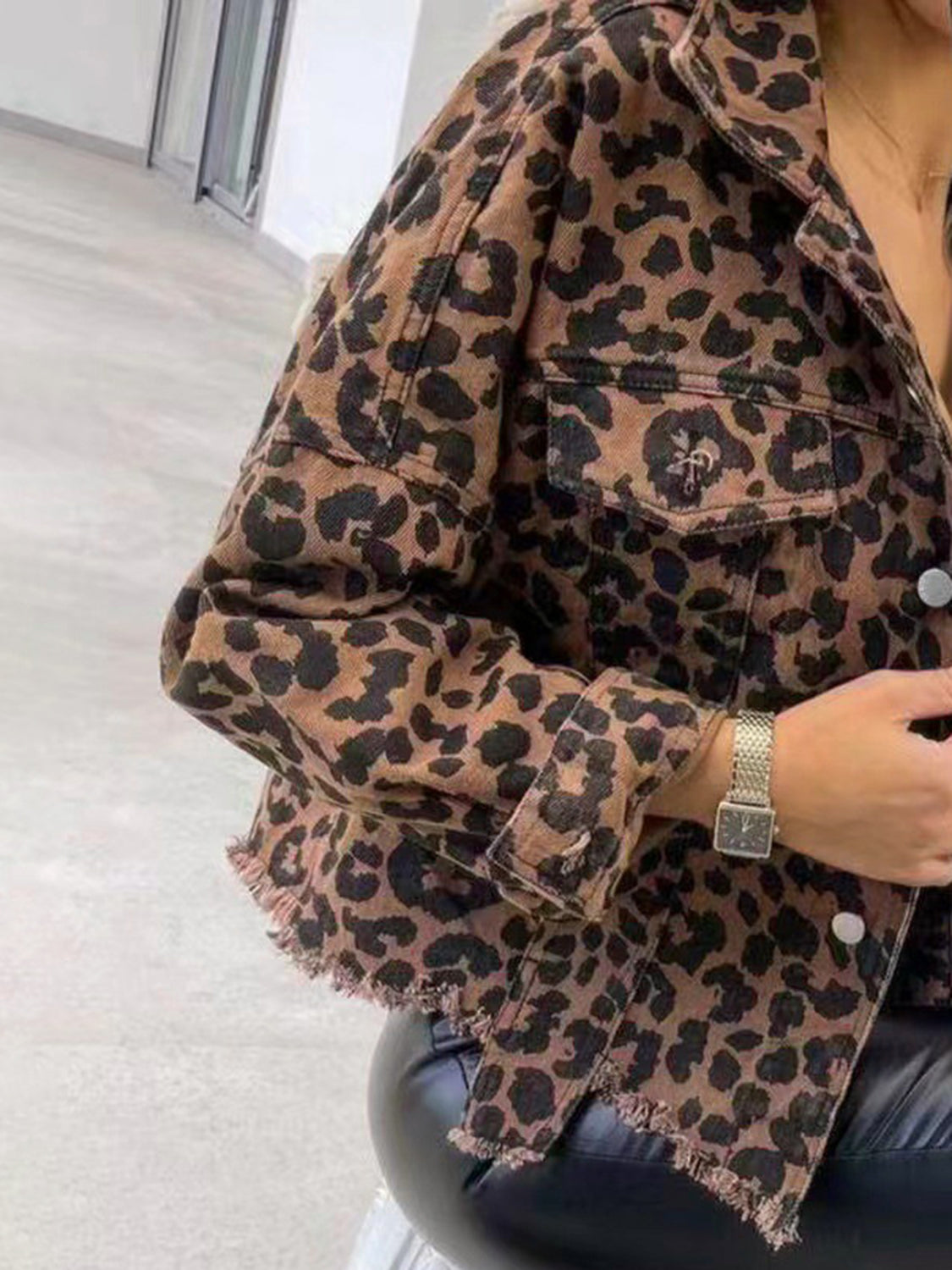 Close-up of leopard print denim jacket with raw hem