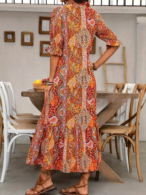 Back view of orange printed tie neck flounce sleeve midi dress