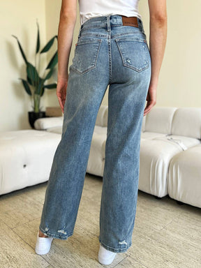 a woman standing in a living room with her back to the camera