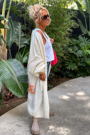 Woman in white cardigan with white shirt and jeans