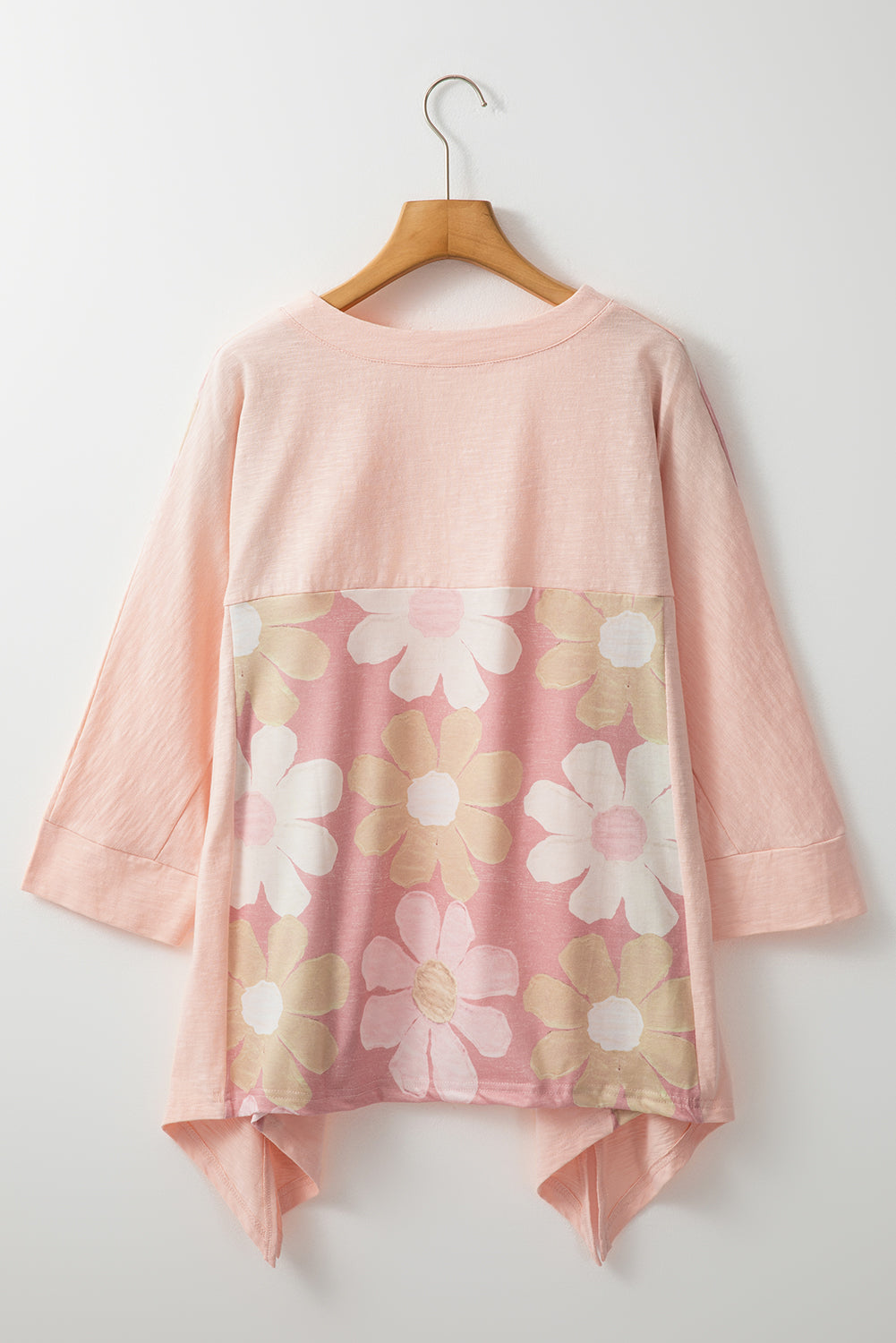 Blush pink floral blouse on hanger with three-quarter sleeves