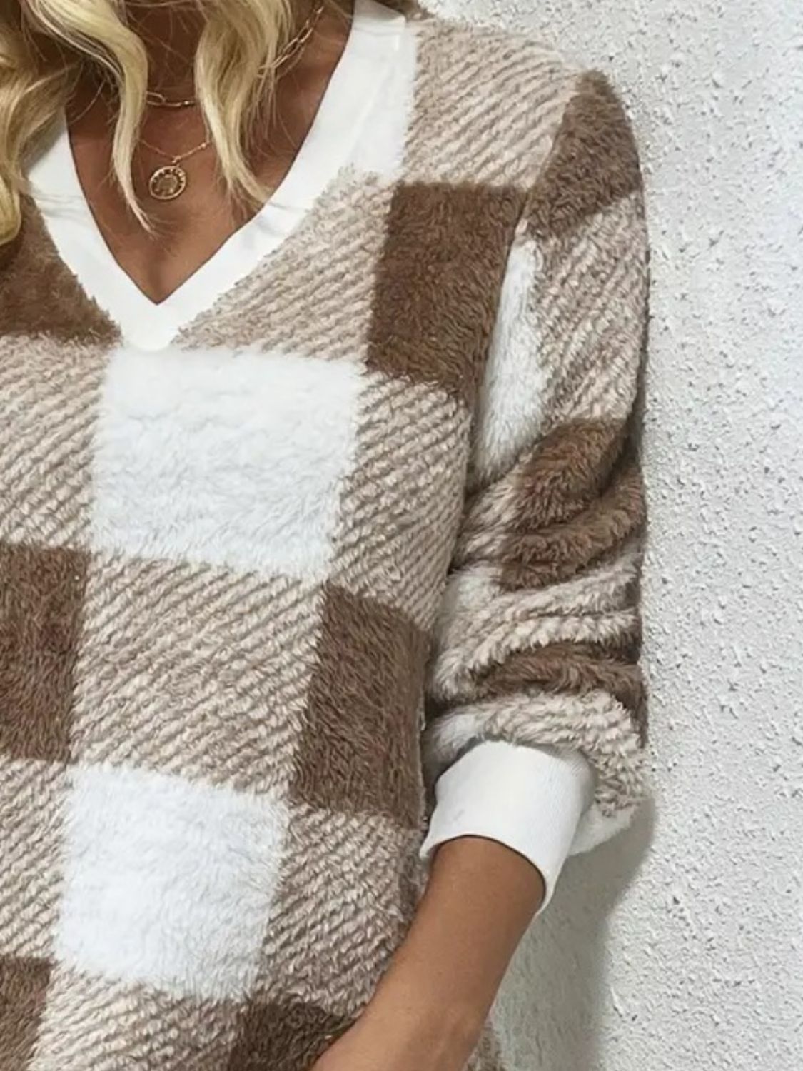 Close-up of taupe plaid V-neck sweater dress fabric