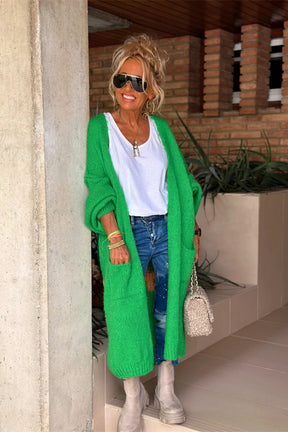 Woman in green cardigan with white shirt and jeans