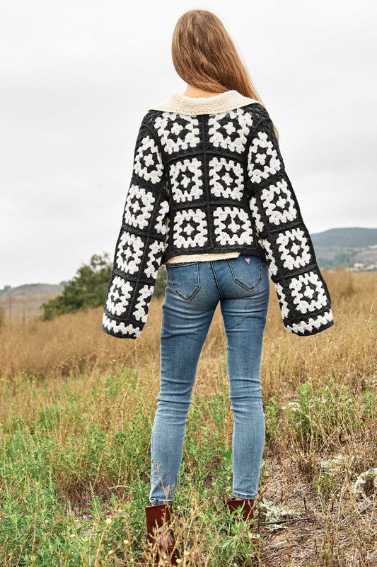 Back view of black and white crochet cardigan.