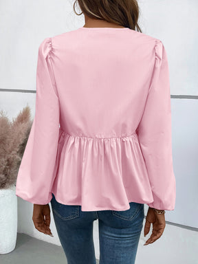 a woman wearing a pink blouse and jeans