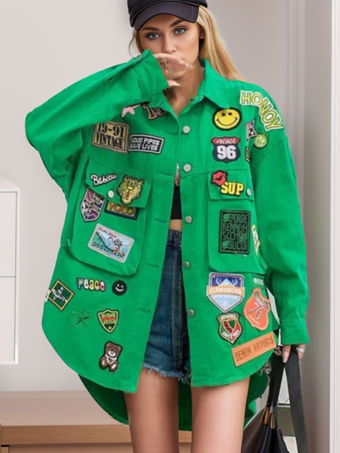 Green jacket with embroidered patches, front view.