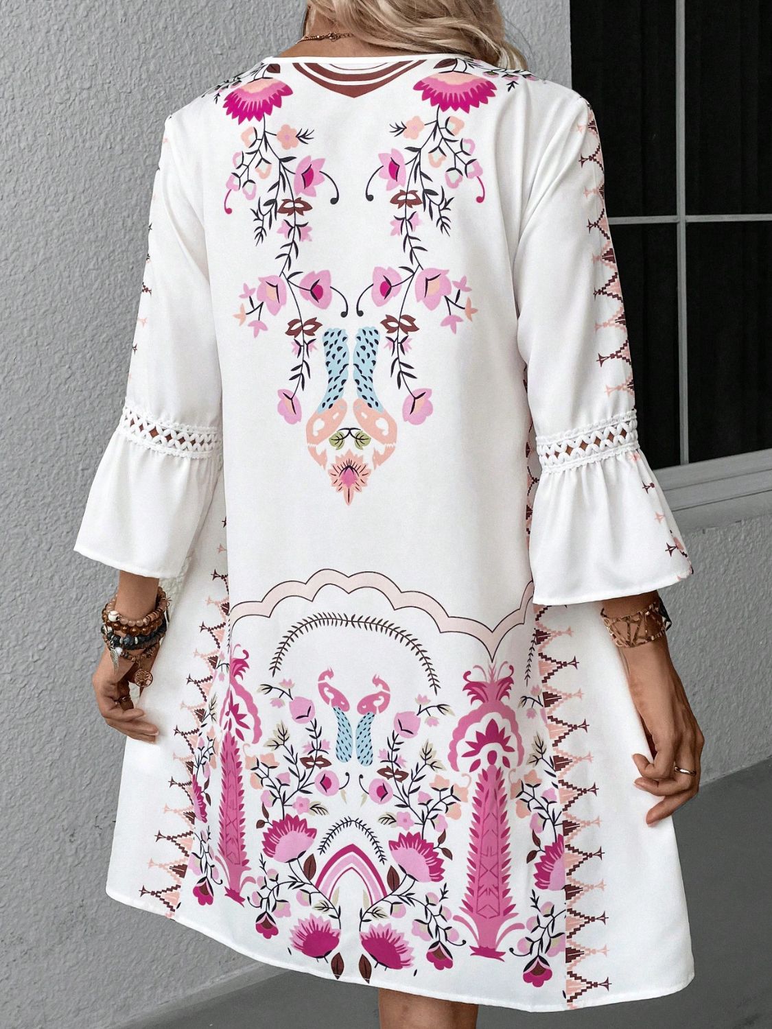 Back view of white printed dress with lace detail sleeves