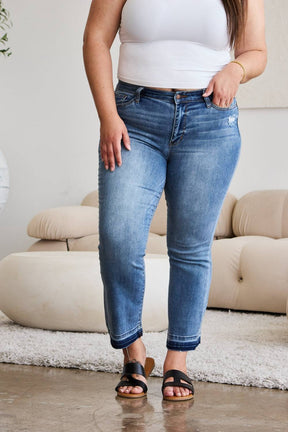 a woman in a white tank top and jeans