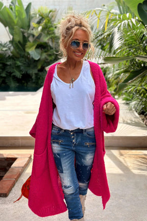 Woman in pink cardigan with white shirt and jeans