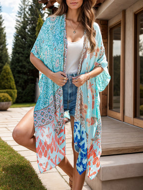 Model wearing blue printed open front cover-up outdoors