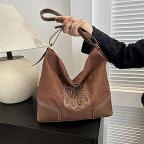 Suede patch tote bag in dark brown with decorative stitching.