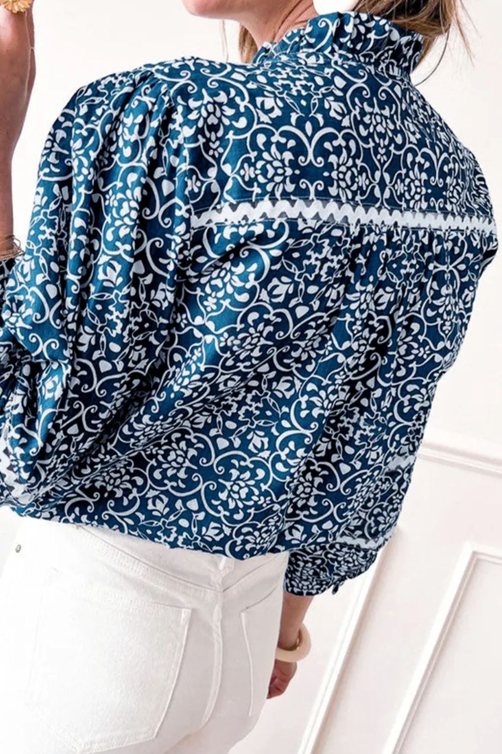 Printed mock neck long sleeve blouse in peacock blue, back view.