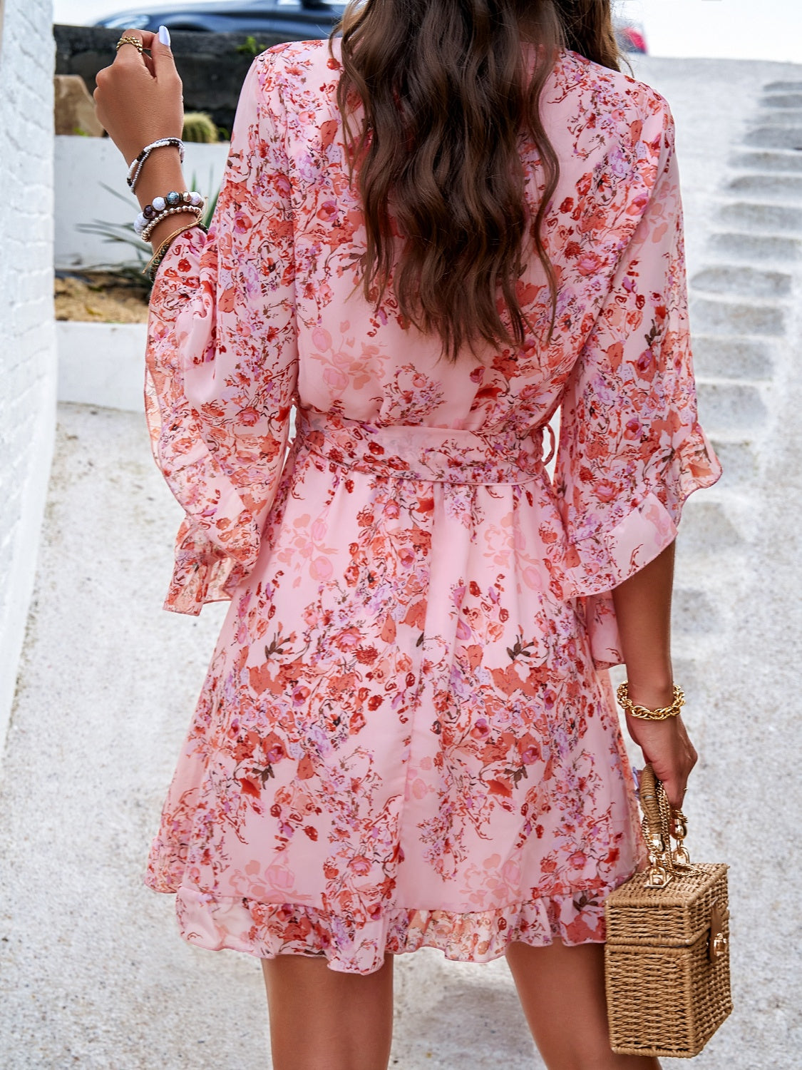 Back view of pink floral ruffled surplice mini dress