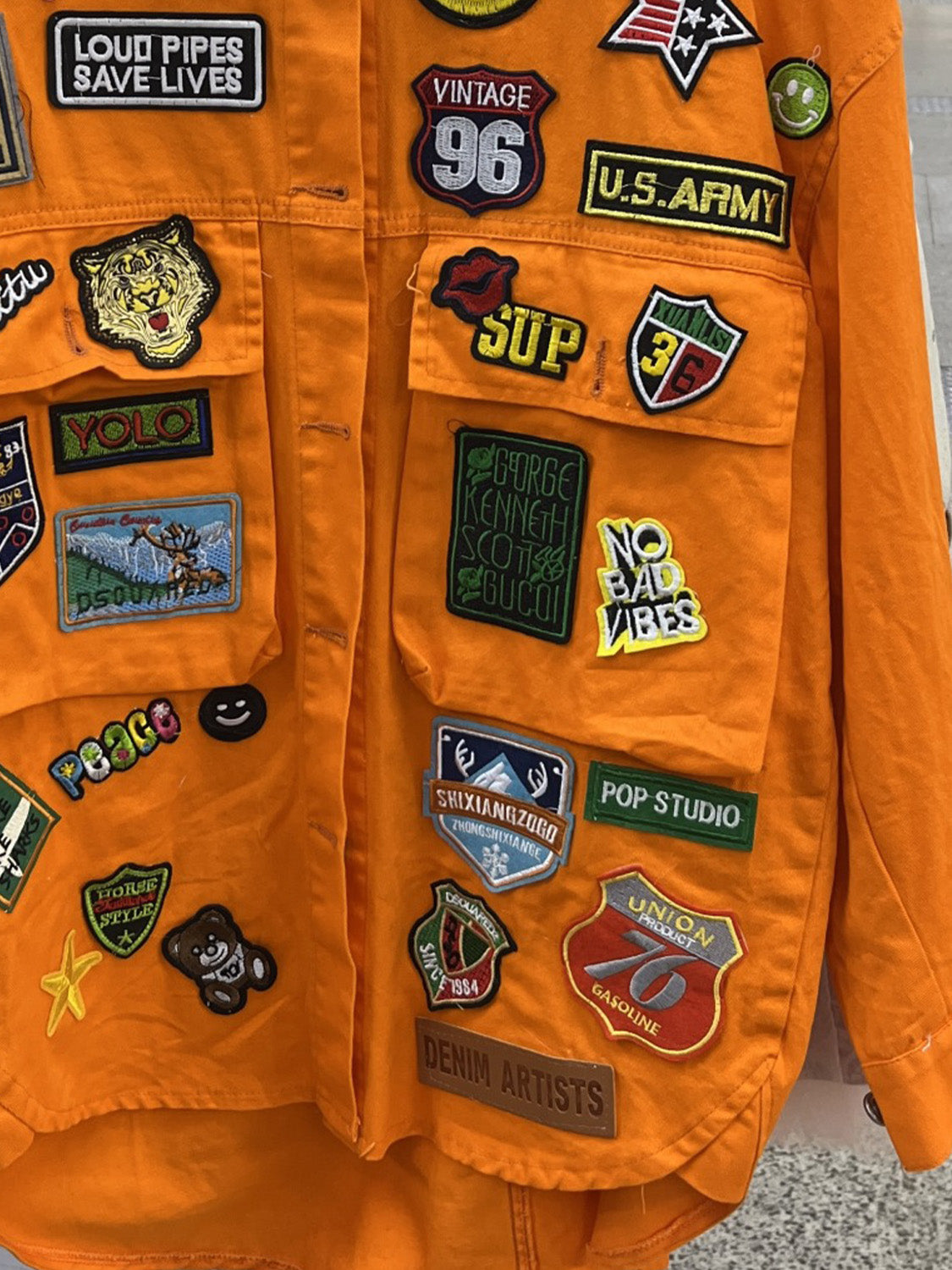 Detailed view of patches on orange jacket.