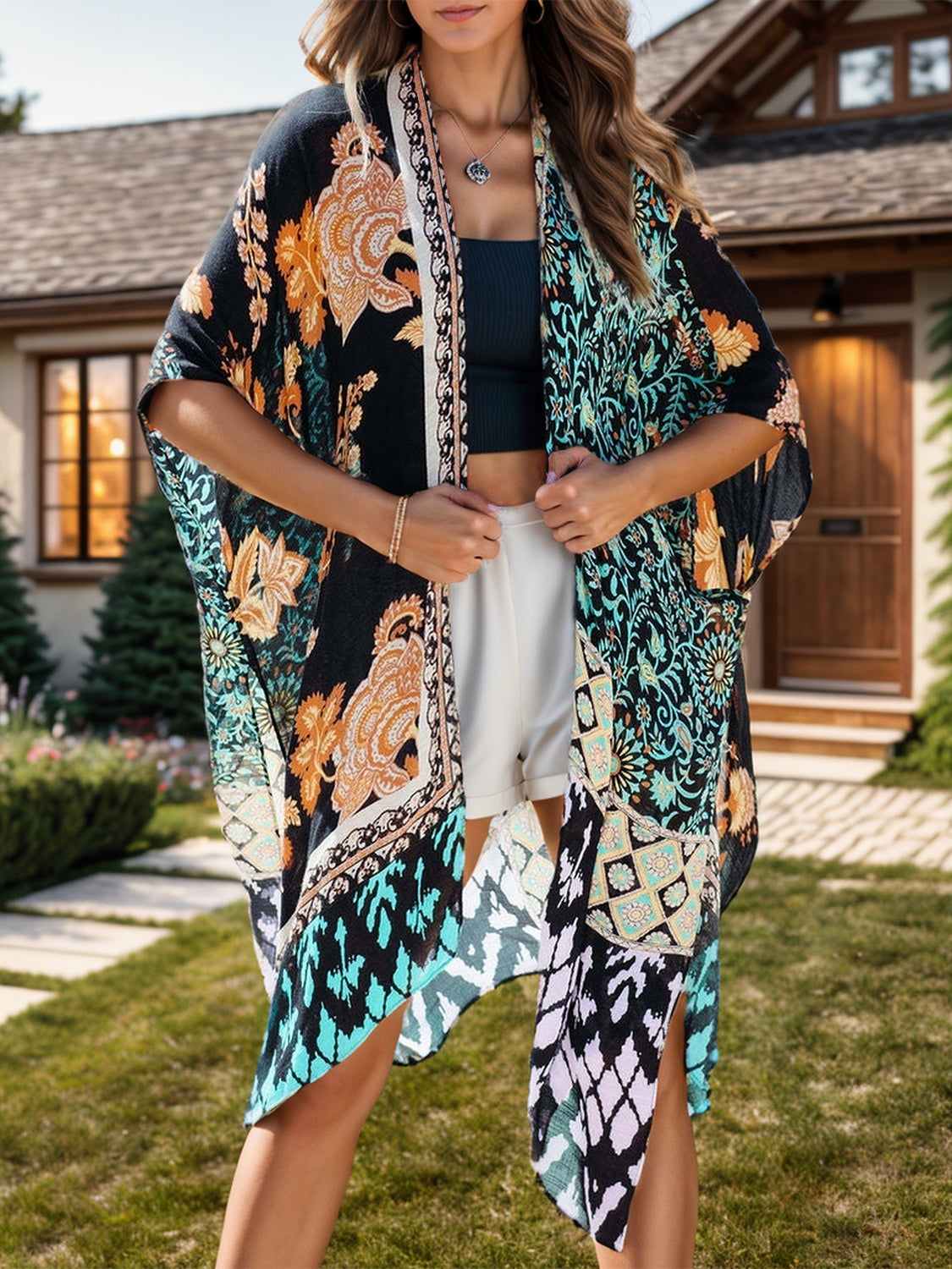 Model in black printed open front cover-up in garden