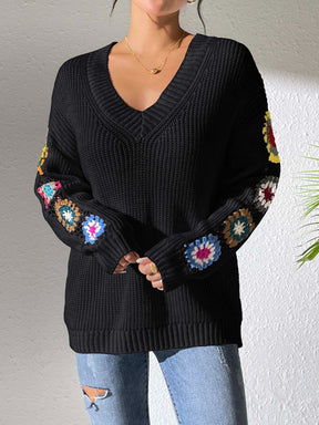 Black crochet flower V-neck sweater with vibrant sleeve accents.