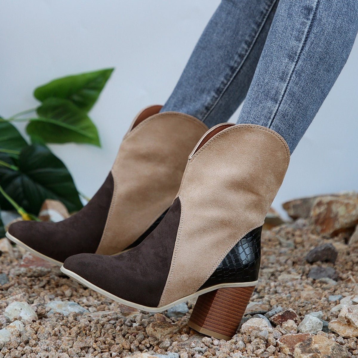 Two-tone suede block heel boots on rocky ground