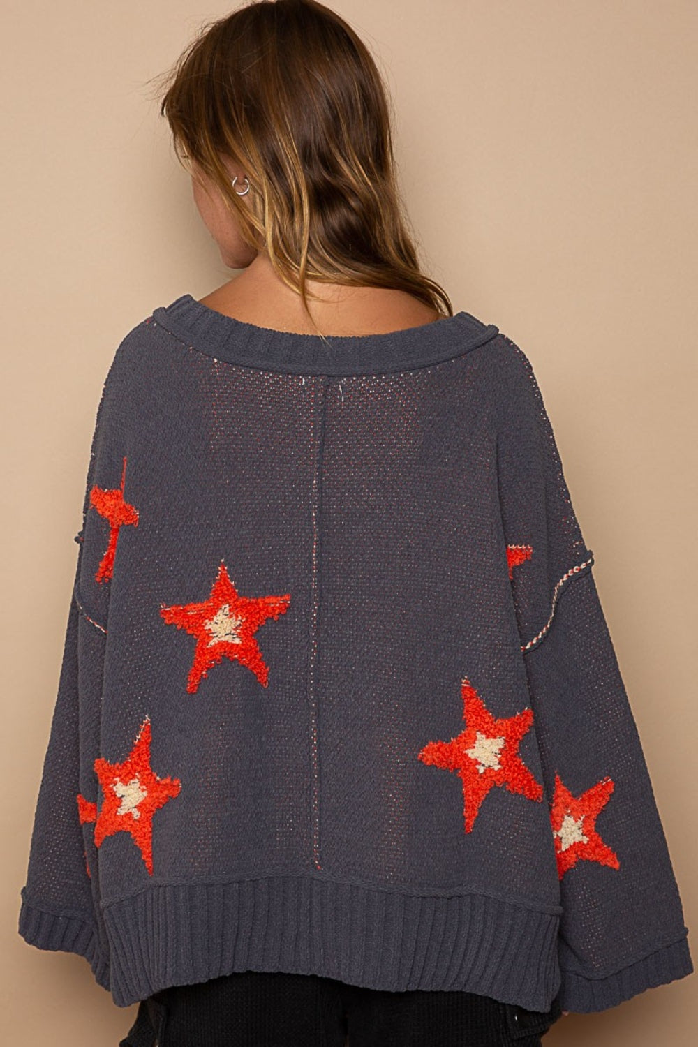 a woman wearing a sweater with red stars on it