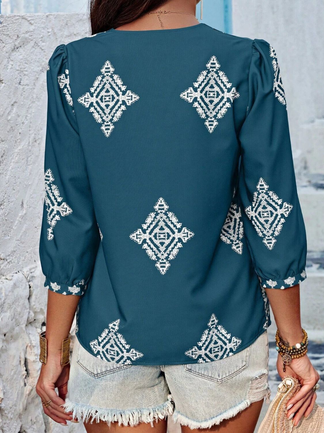 Back view of teal printed V-neck blouse