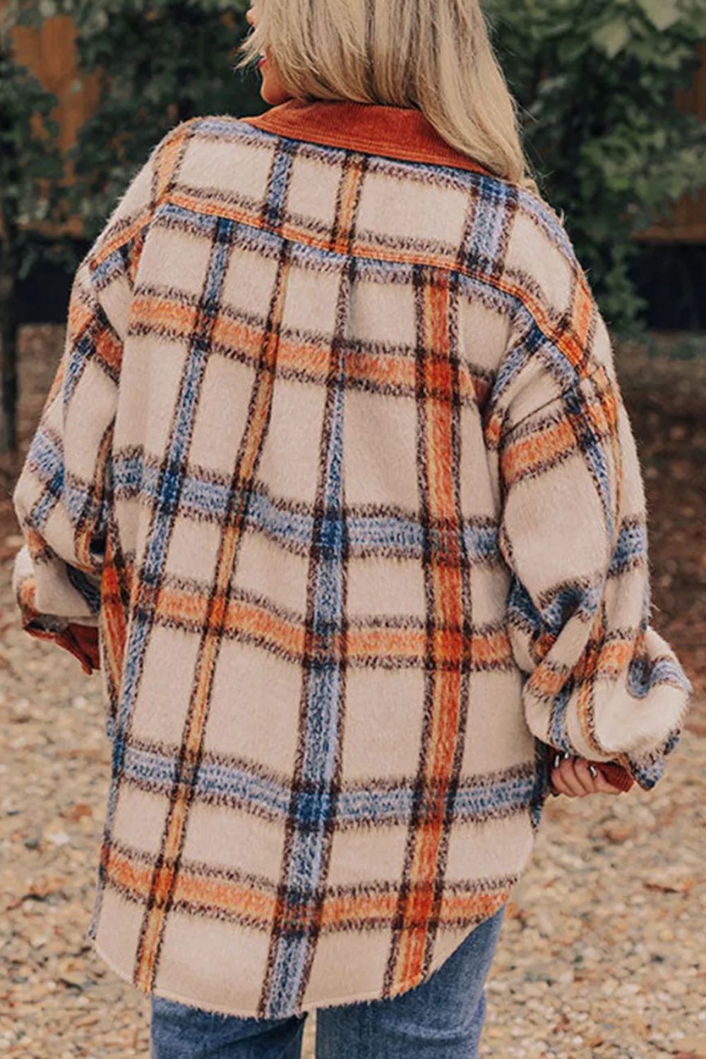 a woman wearing a plaid coat and jeans