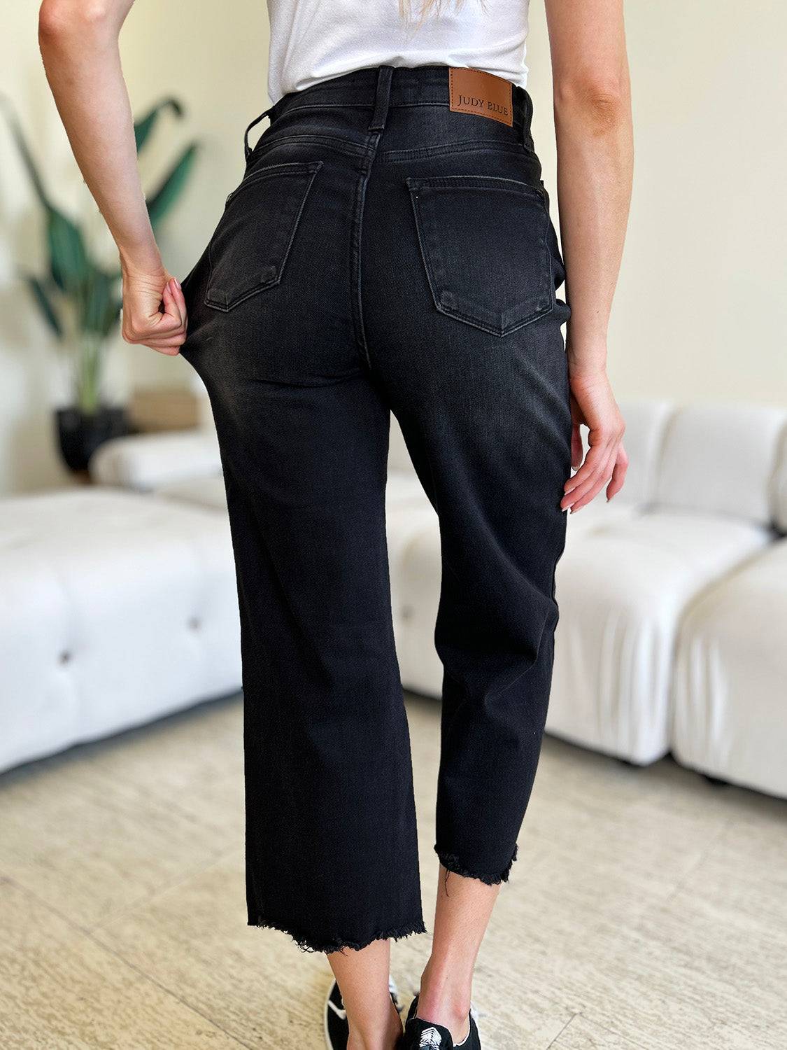 a woman standing in a living room with her back to the camera