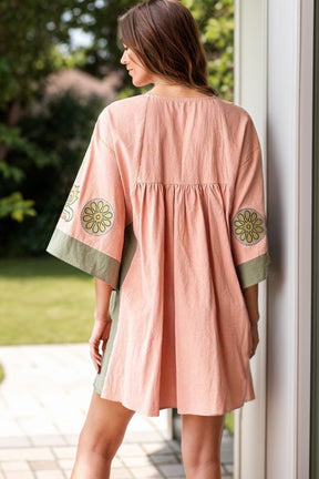 Back view of peach floral mini dress with wide sleeves